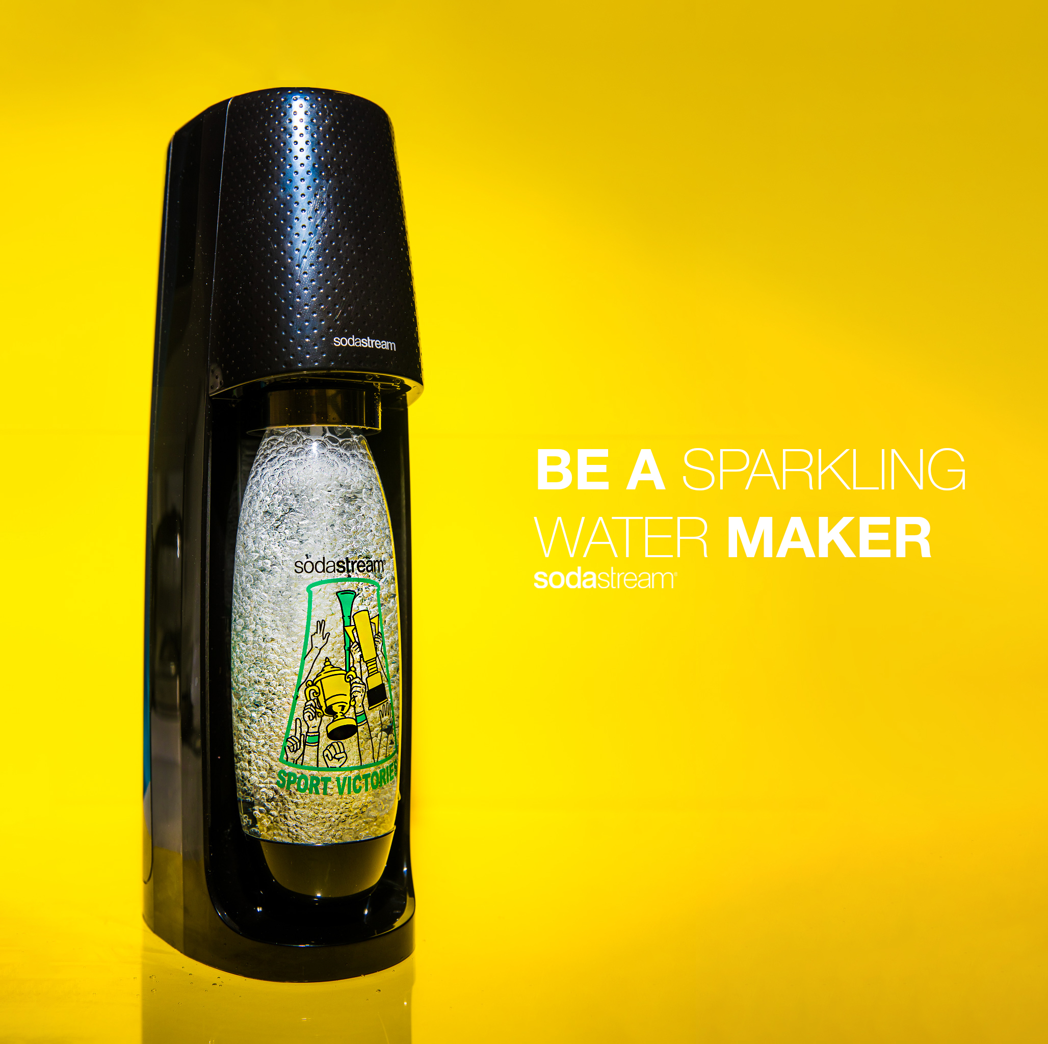  A sodastream actively making sparkling water on a yellow background with the text be a sparkling water maker. 