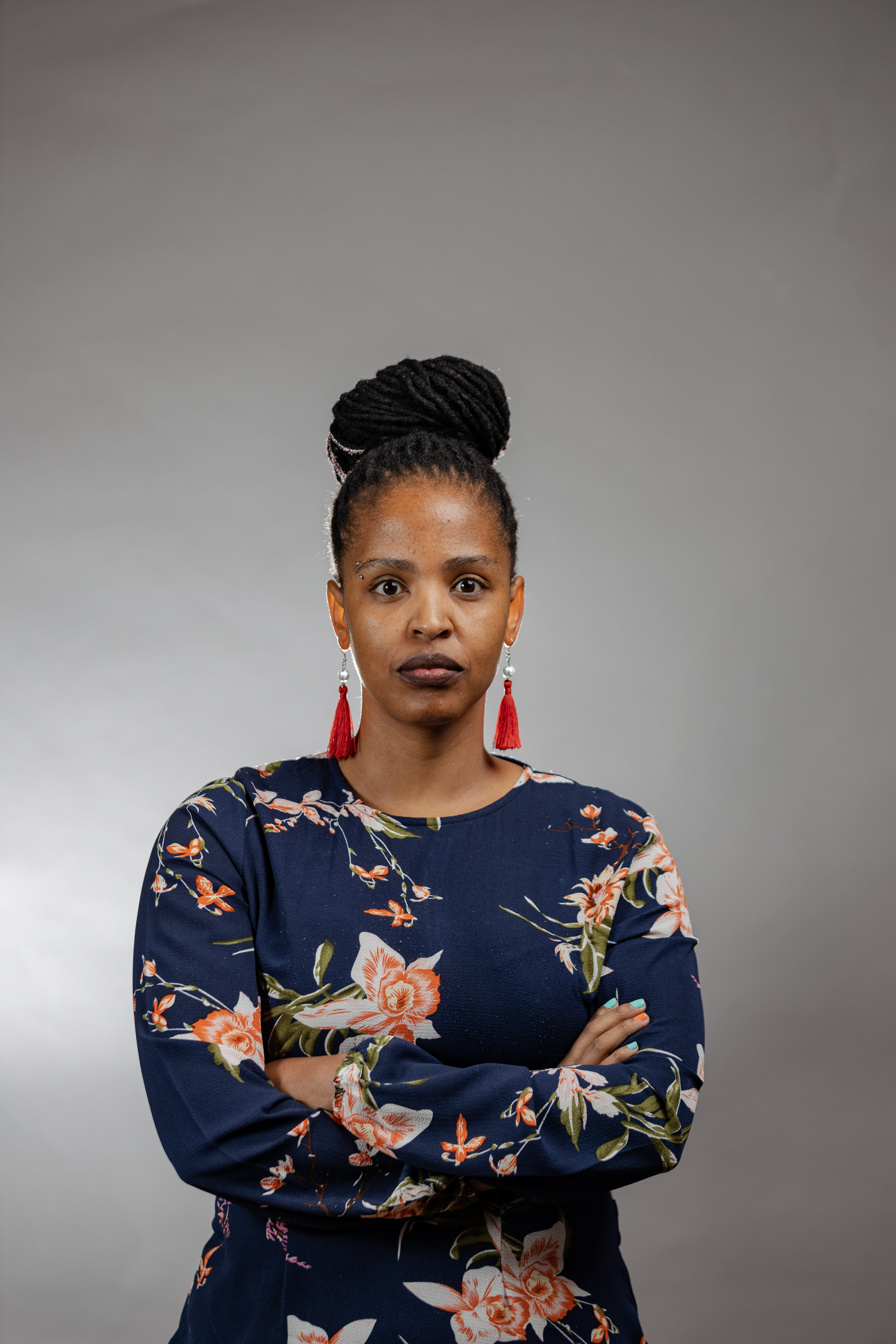 Portrait of a woman wearing floral print with grey background.